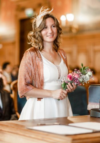 Mariée en robe de mariage blanche tenant des fleurs